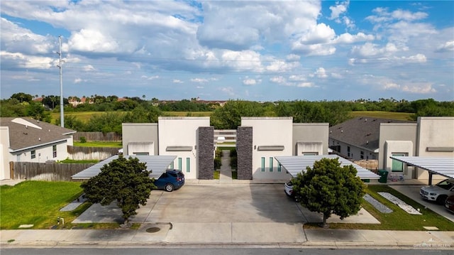 contemporary home with fence, stucco siding, uncovered parking, and a residential view