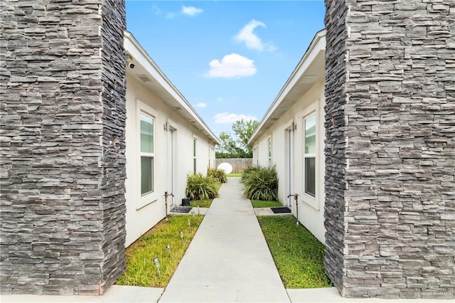 view of side of property with fence and stucco siding