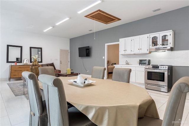 dining area featuring sink and light tile patterned flooring