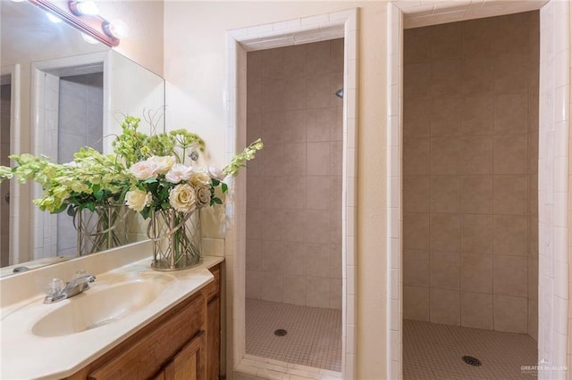 bathroom with a tile shower and vanity