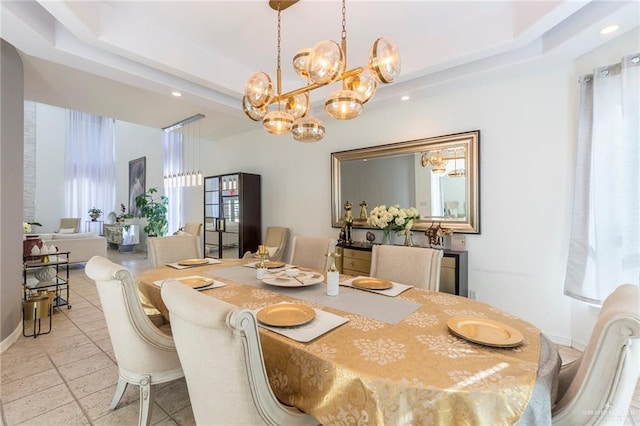 dining space featuring a raised ceiling and an inviting chandelier