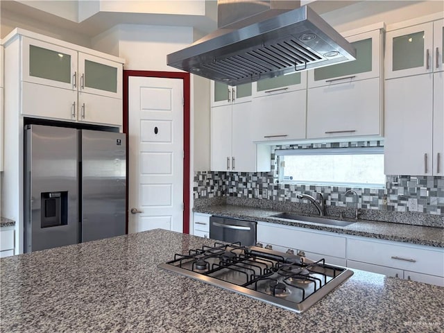 kitchen with wall chimney exhaust hood, decorative backsplash, stainless steel appliances, and a sink