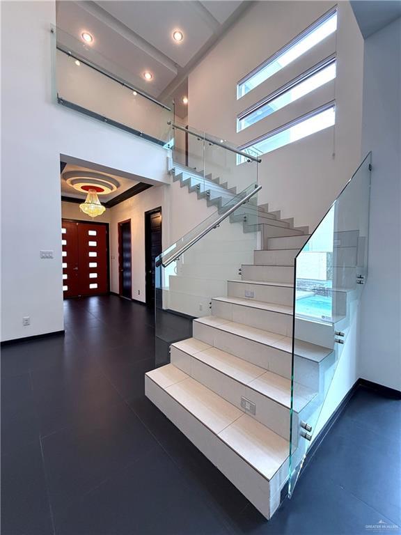 staircase with a towering ceiling and baseboards