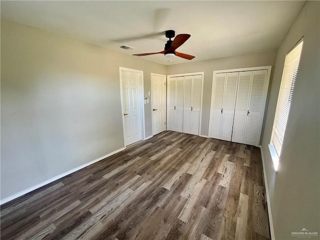 1115 Falcon Dr, Harlingen, TX 78550 - unfurnished bedroom featuring dark hardwood / wood-style flooring, ceiling fan, and multiple closets