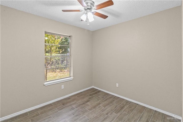 unfurnished room with baseboards, ceiling fan, a textured ceiling, and wood finished floors