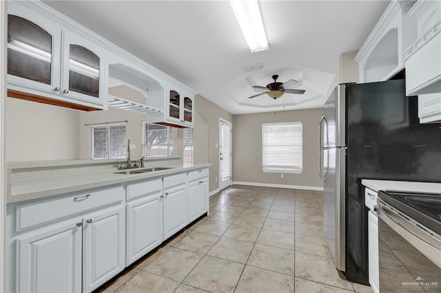 1821 S Petunia Ave, Weslaco, TX 78596 - kitchen with stainless steel electric range, a ceiling fan, light countertops, glass insert cabinets, and white cabinetry
