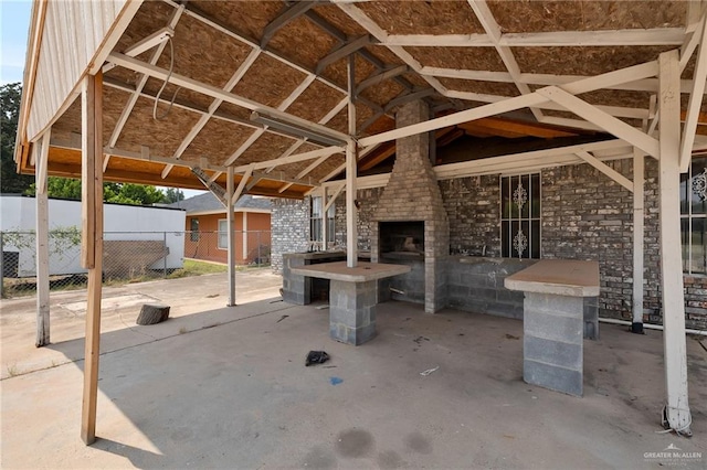 view of patio / terrace featuring a gazebo and an outdoor brick fireplace