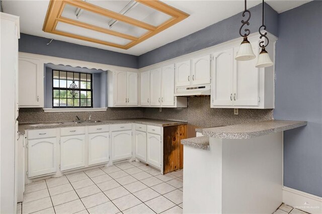 kitchen featuring white cabinetry, sink, light tile patterned floors, and hanging light fixtures