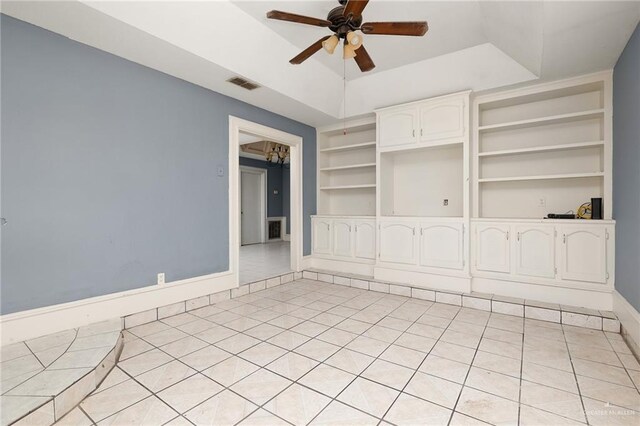 unfurnished living room featuring built in shelves, ceiling fan with notable chandelier, and light tile patterned floors