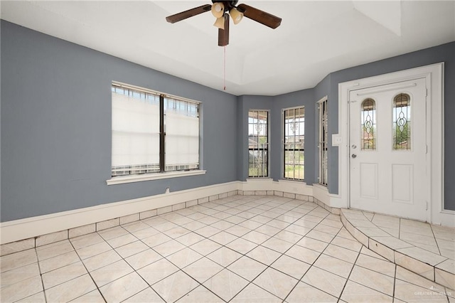 entrance foyer featuring light tile patterned floors, a wealth of natural light, and ceiling fan