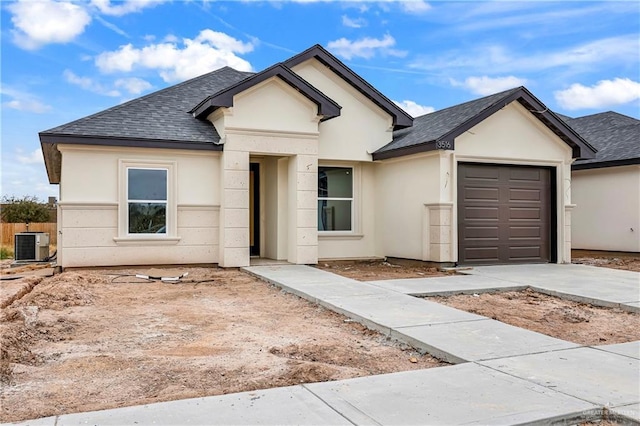 view of front of property with cooling unit and a garage