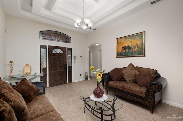 1904 E Hibiscus Ave, Hidalgo, TX 78557 - living room featuring arched walkways, a raised ceiling, a chandelier, baseboards, and a towering ceiling