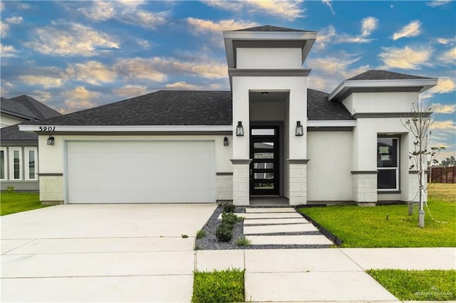 contemporary house featuring a front yard and a garage