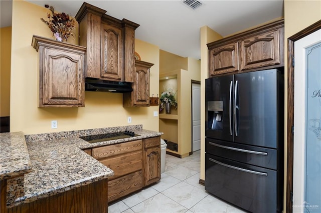 5514 N Minnesota Rd, Mission, TX 78574 - kitchen with refrigerator with ice dispenser, under cabinet range hood, black electric cooktop, and light stone countertops