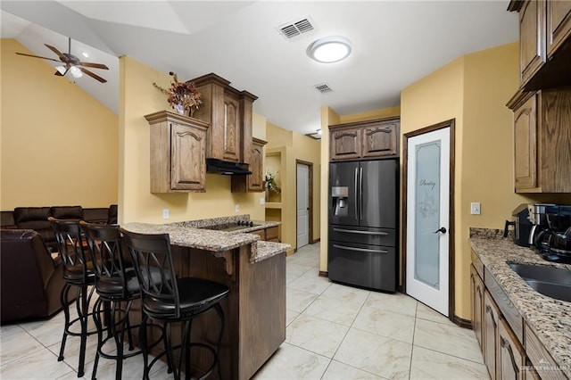5514 N Minnesota Rd, Mission, TX 78574 - kitchen with stainless steel fridge with ice dispenser, under cabinet range hood, a kitchen bar, lofted ceiling, and a ceiling fan