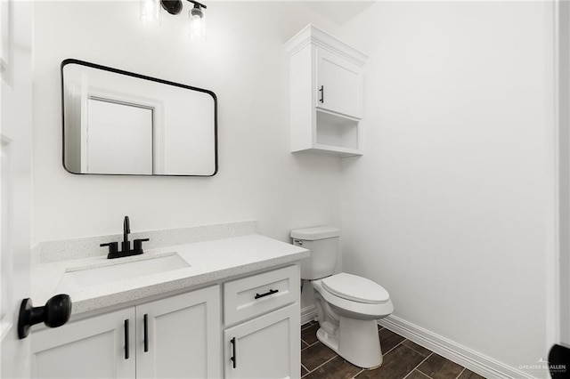 bathroom featuring vanity, wood-type flooring, and toilet