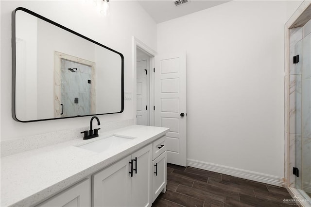 bathroom with a shower with shower door, wood-type flooring, and vanity