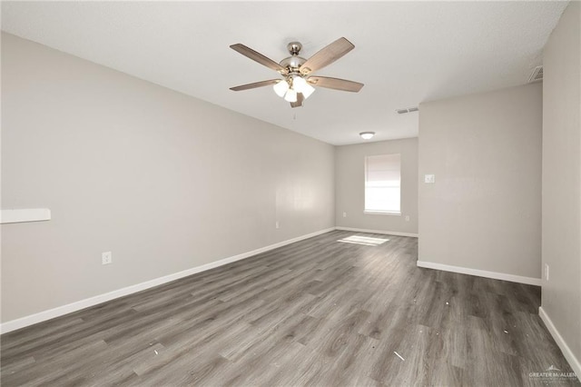 spare room featuring dark wood-type flooring and ceiling fan