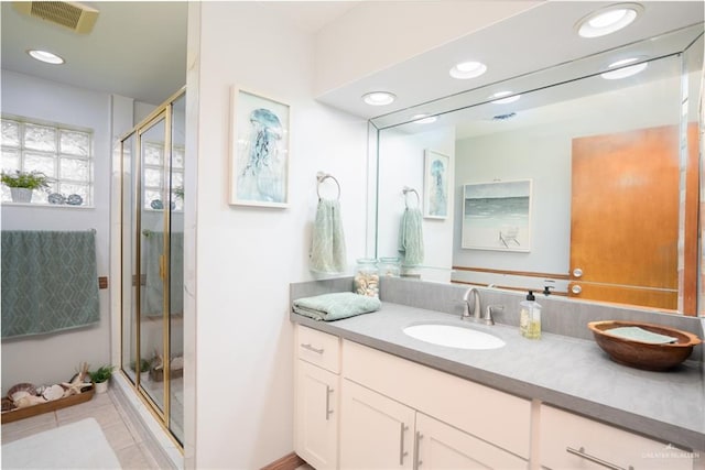 bathroom featuring tile patterned flooring, vanity, and a shower with shower door