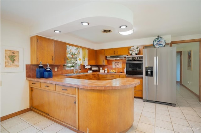 5129 N Mile 5 1/2 Rd W, Weslaco, TX 78599 - kitchen featuring black oven, stainless steel fridge, a peninsula, under cabinet range hood, and light tile patterned floors