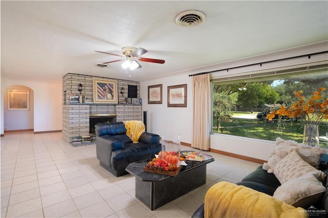 5129 N Mile 5 1/2 Rd W, Weslaco, TX 78599 - living area featuring light tile patterned floors, ceiling fan, arched walkways, a brick fireplace, and baseboards