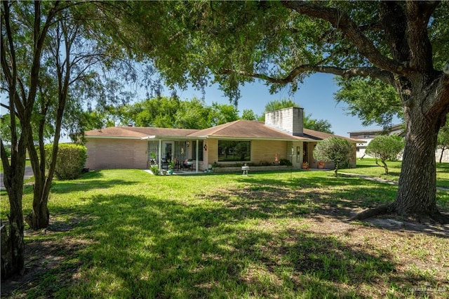 5129 N Mile 5 1/2 Rd W, Weslaco, TX 78599 - ranch-style house featuring a front lawn and a chimney