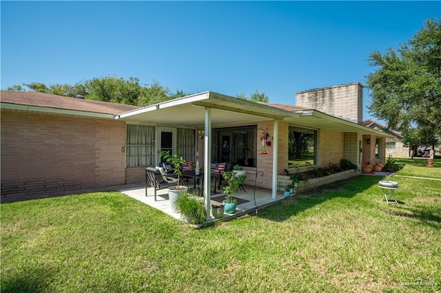 back of property with a patio area and a lawn