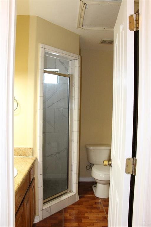 bathroom with hardwood / wood-style floors, vanity, an enclosed shower, and toilet