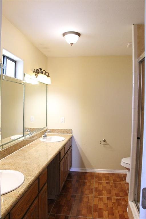 bathroom with vanity, toilet, and a shower with shower door