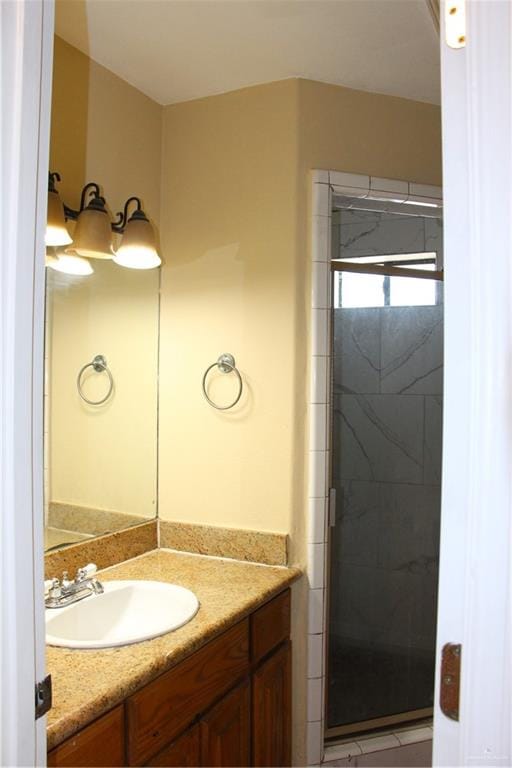 bathroom with vanity and a shower with door