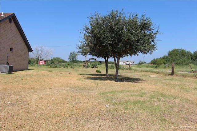 view of yard featuring a rural view and central air condition unit