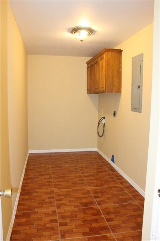 laundry room with electric dryer hookup, electric panel, dark hardwood / wood-style flooring, and cabinets