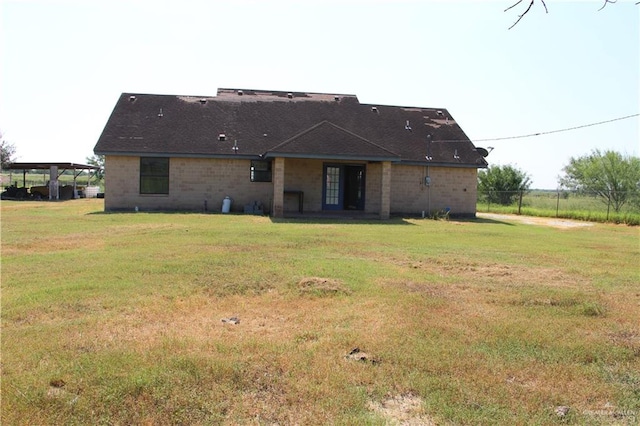 rear view of property with a yard