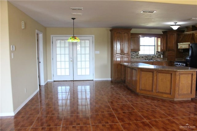 kitchen featuring backsplash, french doors, sink, hanging light fixtures, and kitchen peninsula