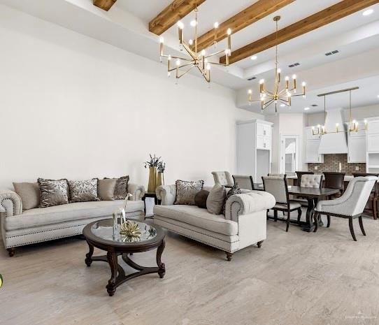 living room featuring beamed ceiling, a high ceiling, and an inviting chandelier