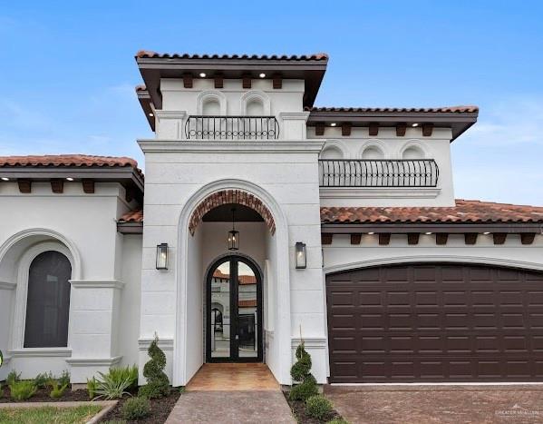 view of exterior entry featuring a balcony and a garage