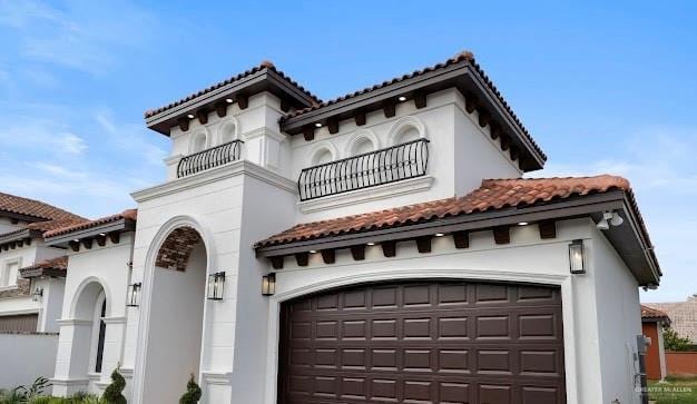 mediterranean / spanish house with a garage and a balcony