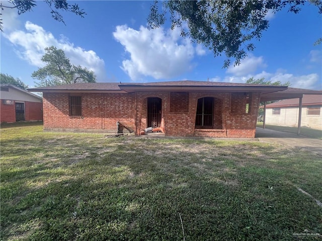 1116 S Orange St, Mercedes, TX 78570 - back of property featuring brick siding, a carport, and a lawn