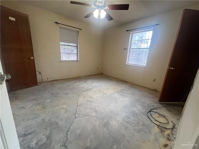 1116 S Orange St, Mercedes, TX 78570 - unfurnished bedroom featuring multiple windows, a textured ceiling, and a ceiling fan