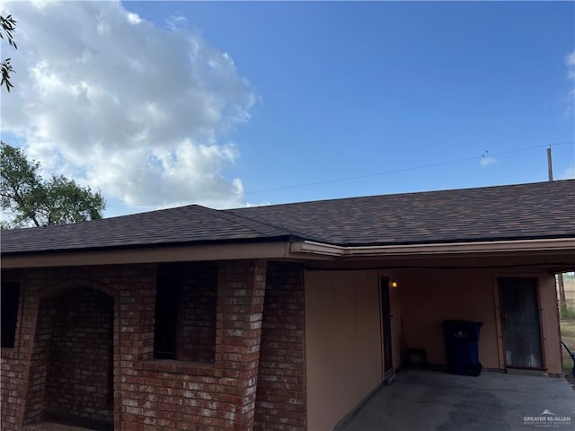 1116 S Orange St, Mercedes, TX 78570 - view of side of home with a shingled roof, an attached carport, and brick siding