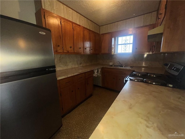 1116 S Orange St, Mercedes, TX 78570 - kitchen with freestanding refrigerator, black range with electric stovetop, under cabinet range hood, light countertops, and tasteful backsplash