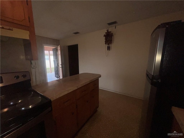 1116 S Orange St, Mercedes, TX 78570 - kitchen featuring electric stove, freestanding refrigerator, a peninsula, arched walkways, and light colored carpet