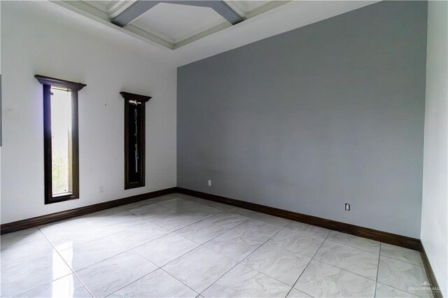 unfurnished room with beam ceiling