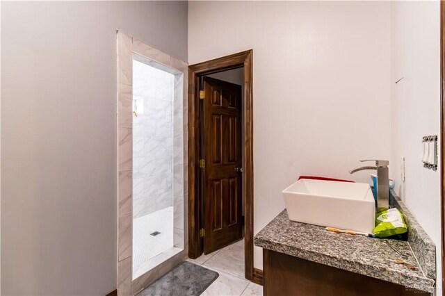 bathroom featuring a tile shower and sink