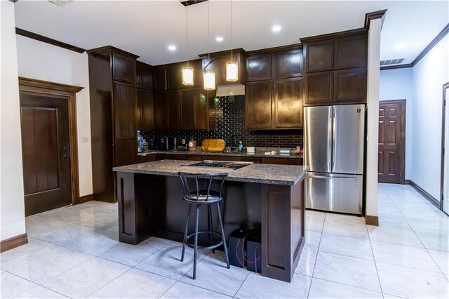 kitchen featuring pendant lighting, a center island, dark stone counters, crown molding, and appliances with stainless steel finishes