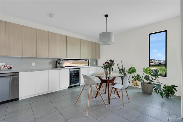 kitchen featuring pendant lighting, beverage cooler, modern cabinets, light countertops, and dishwasher