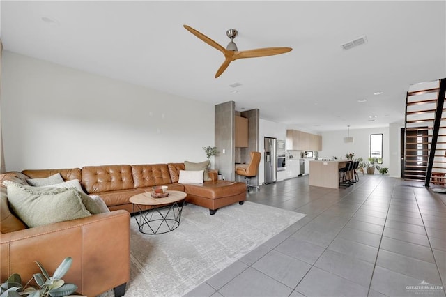 tiled living area with a ceiling fan and visible vents