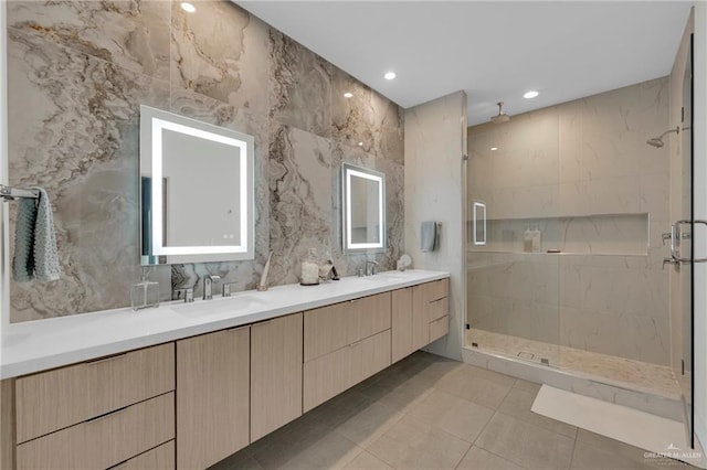 full bathroom featuring tile patterned flooring, a sink, a marble finish shower, and double vanity