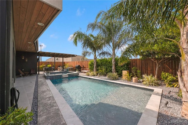 view of swimming pool featuring a fenced backyard, a pool with connected hot tub, and a patio area