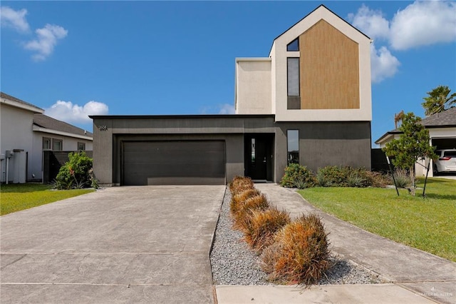 contemporary house featuring an attached garage, driveway, and a front yard